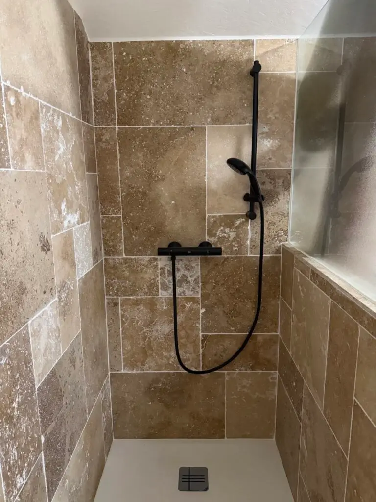 Douche à l’italienne en pierre naturelle avec robinetterie noire